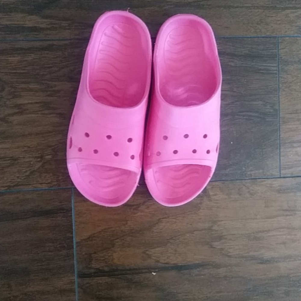 A pair of pink sandals over night bags